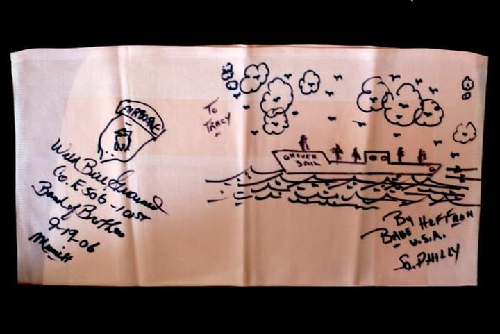 A hand-drawn sketch on a beige cloth depicts a ship labeled 'DRIVER SAIL' sailing on wavy water with clouds and birds above…