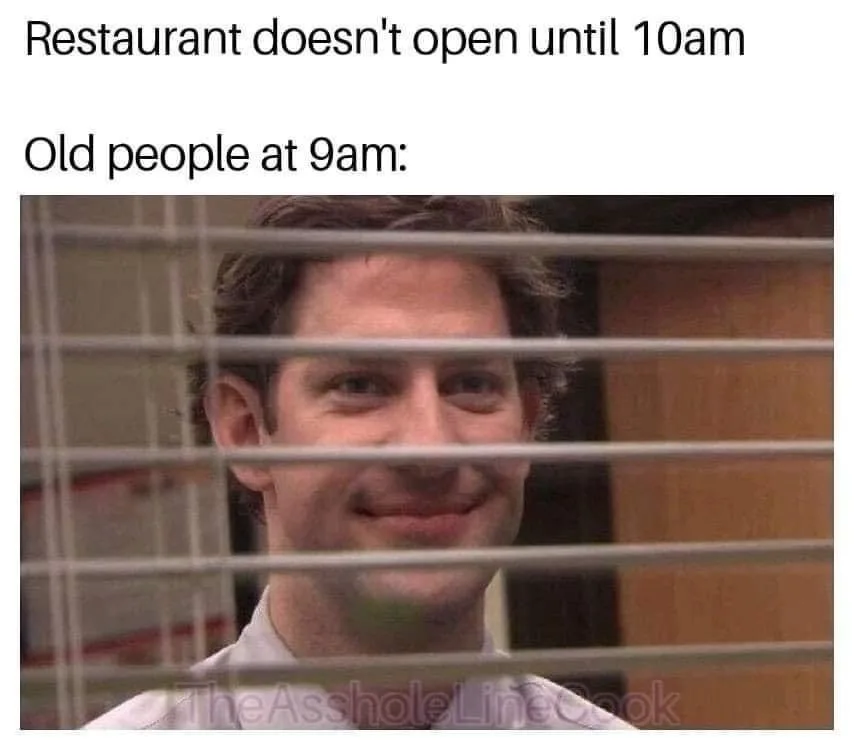 A man with a smug, knowing smile peers through horizontal window blinds. The text above reads 'Restaurant doesn't open until…