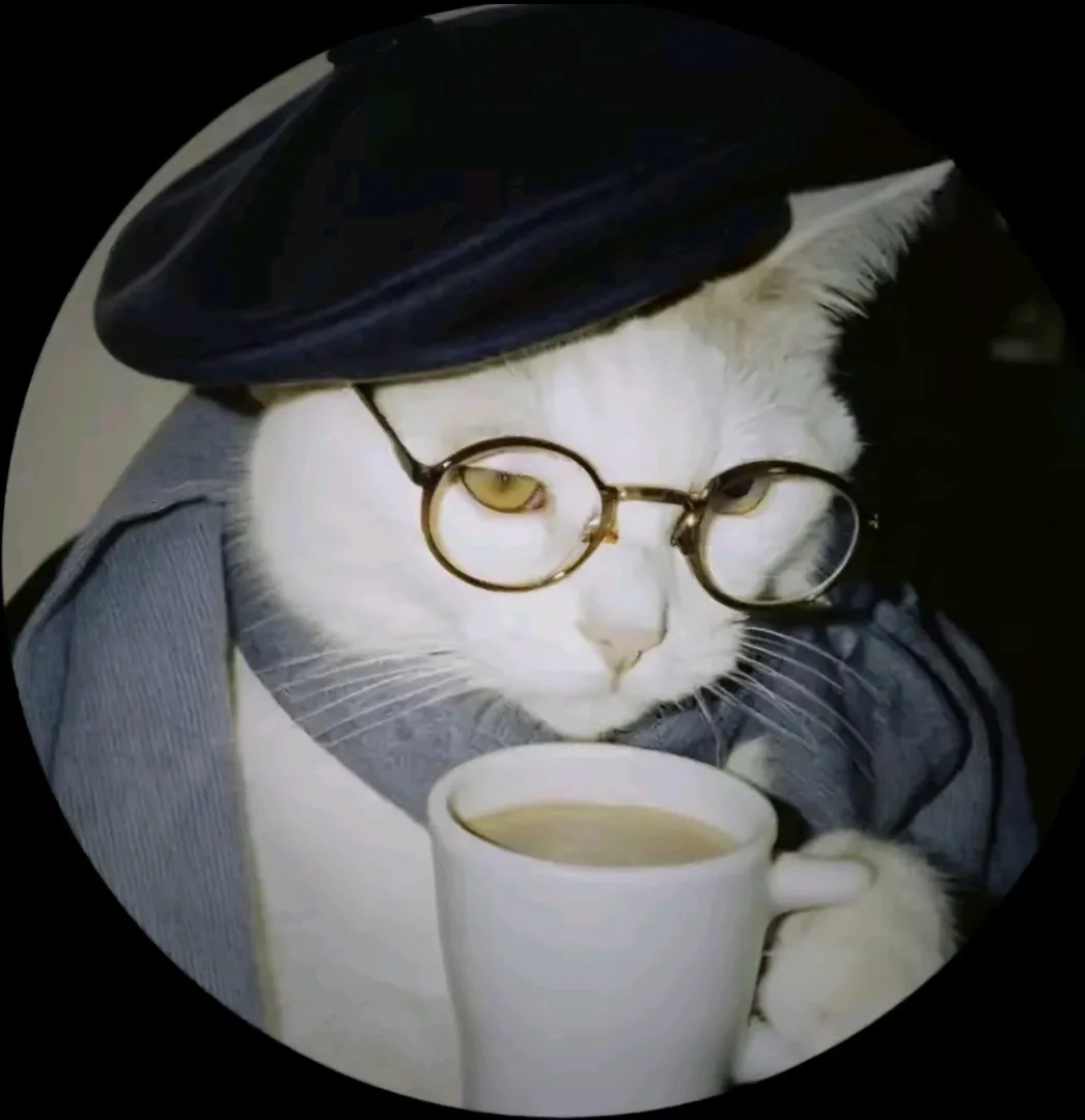 A white cat wearing a dark blue beret and round glasses, dressed in a blue jacket, holds a white mug and looks down with a…