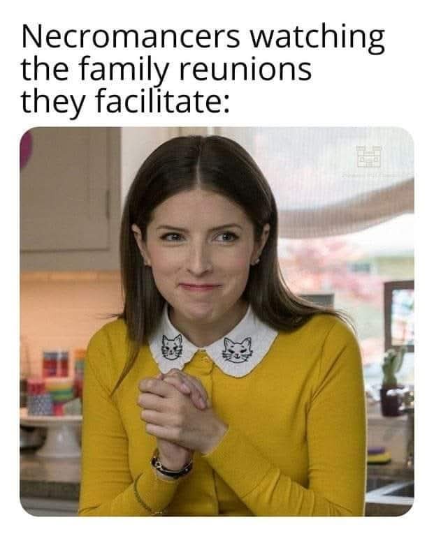 A woman in a yellow sweater with a white collar featuring cat faces looks at the camera with a subtle, knowing smirk while…