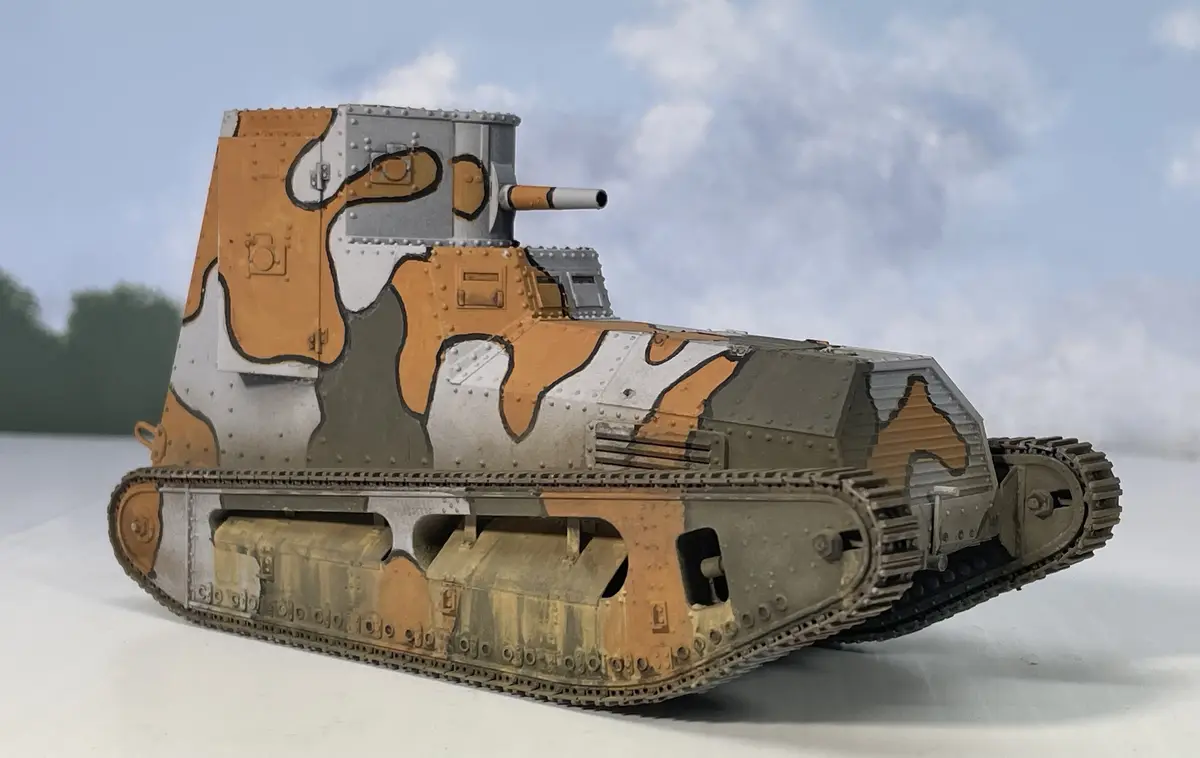 A detailed model of a World War I-era tank, likely a Renault FT, is shown with a distinctive orange, grey, and white…