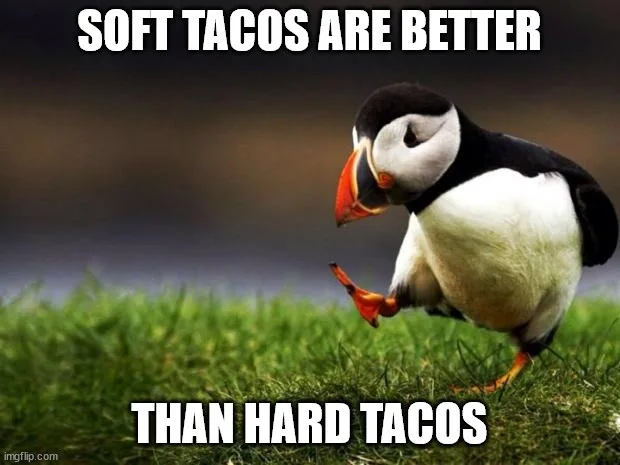 A penguin stands on green grass, looking down with one foot lifted, as if contemplating. White bold text at the top reads…