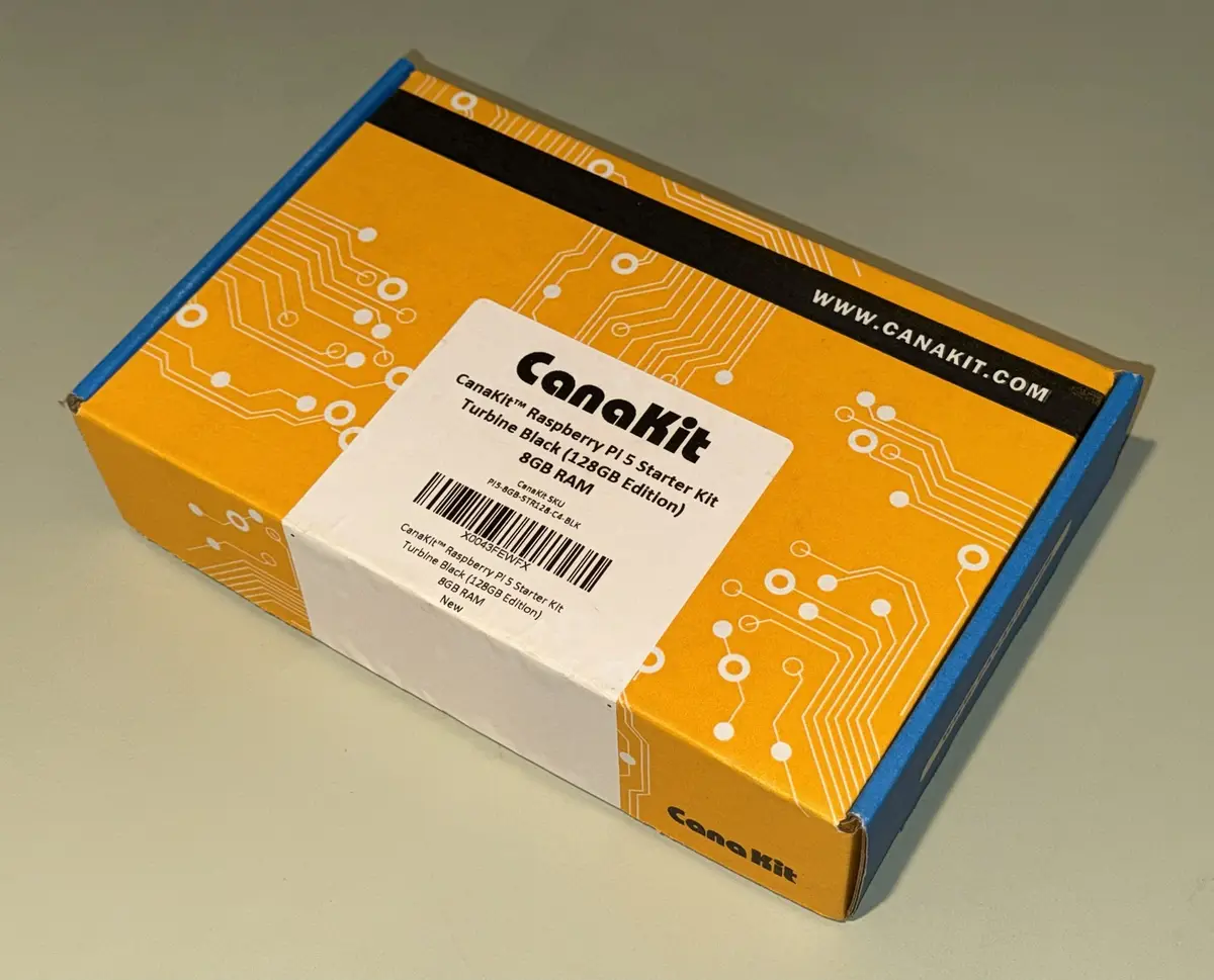 A yellow and blue cardboard box with white circuit board patterns, labeled as a CanaKit Raspberry Pi 5 Starter Kit with 8GB…