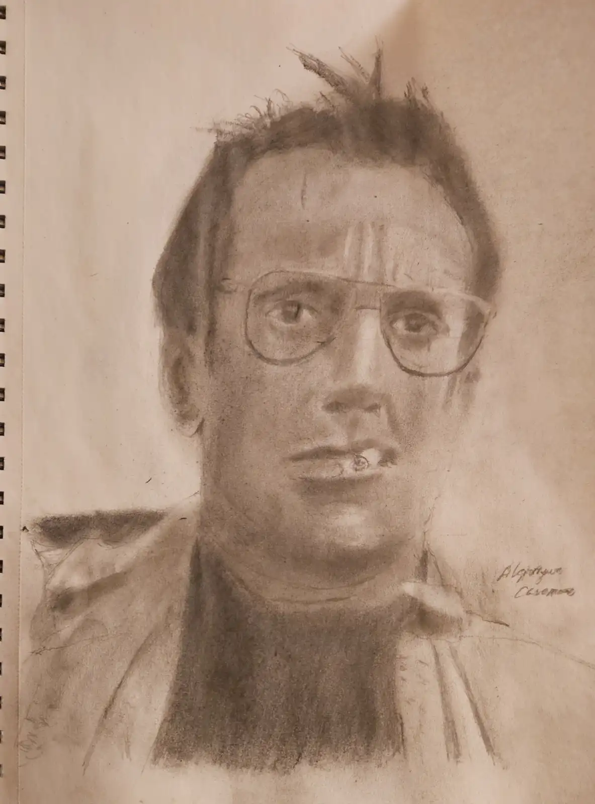 A sepia-toned pencil sketch of a man with glasses and messy hair, smoking a cigarette, drawn on spiral-bound paper. The…