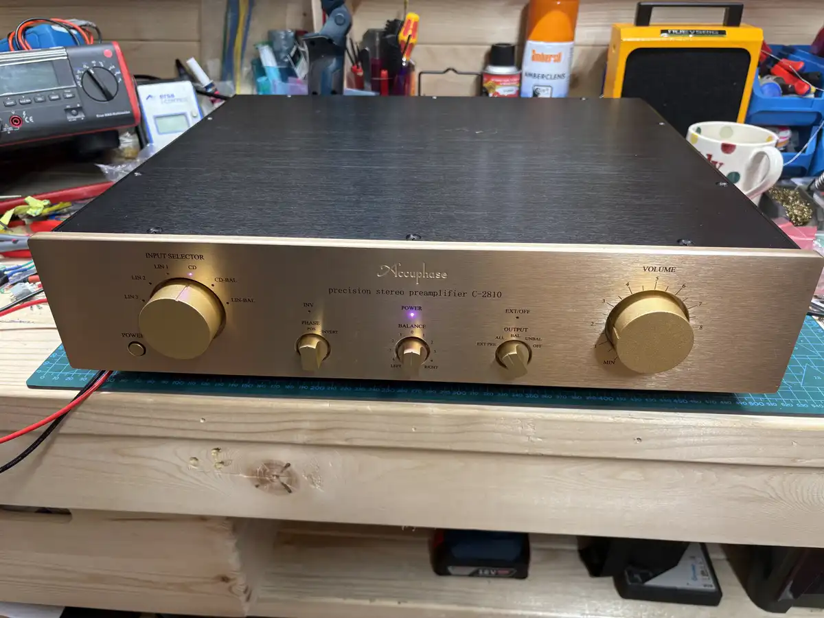 A close-up photo of an Accuphase C-2810 precision stereo preamplifier, featuring gold knobs and a black top panel, sitting…
