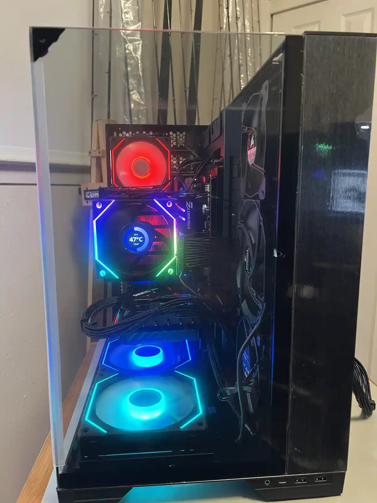 A black computer case with a transparent side panel reveals a custom water-cooled PC with RGB lighting. The CPU cooler's fan…