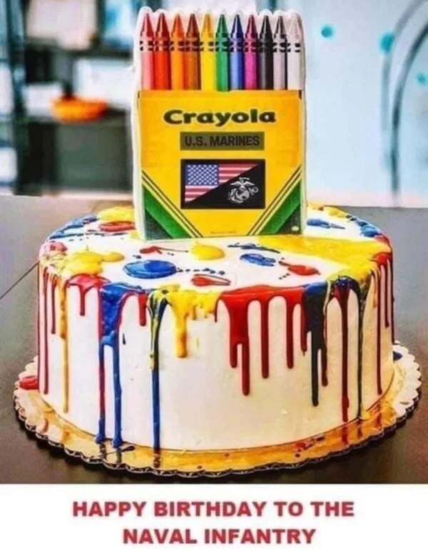 A birthday cake decorated with colorful dripping icing resembling melted crayons, topped with a box labeled 'Crayola U.S…