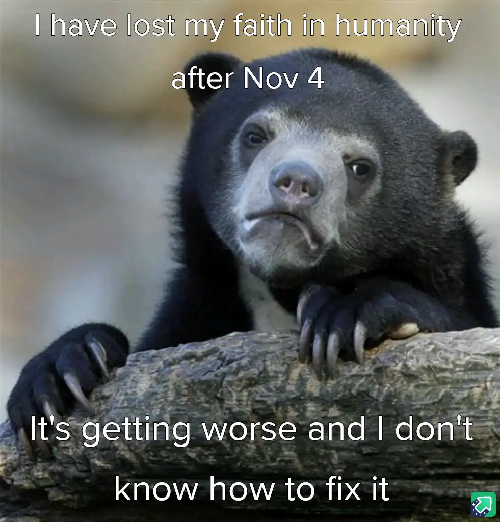 A close-up photo of a sad-looking, dark-furred bear with a downturned mouth, resting its paws on a log. White text overlaid…