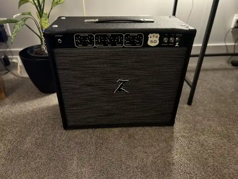 A black, textured guitar amplifier with a 'Z' logo on the front grille and control knobs labeled 'Volume', 'EQ', and…