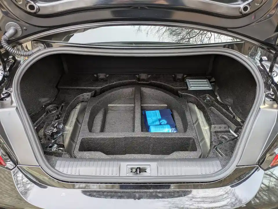 The image shows the open trunk of a silver Subaru, which is mostly empty except for a few small items like the owner's…
