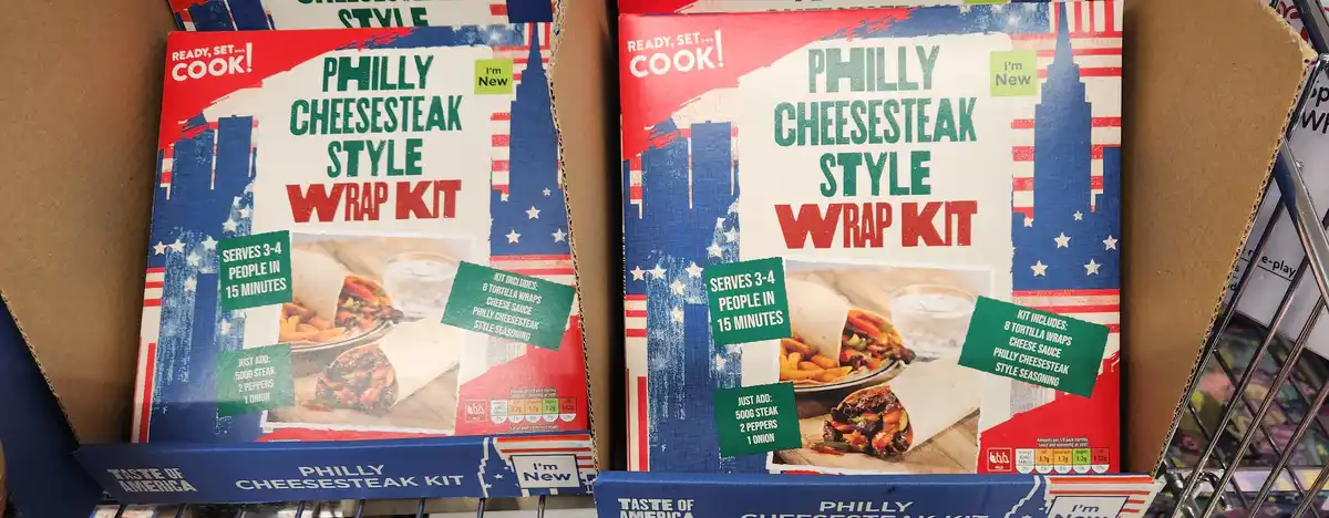 Two identical boxes of 'Philly Cheesesteak Style Wrap Kit' are displayed side-by-side on a store shelf. The packaging…