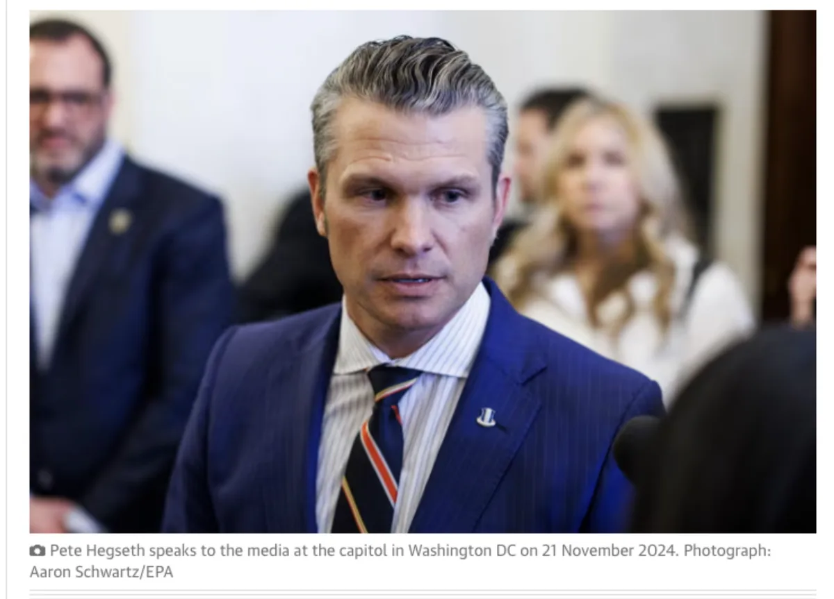 A man in a blue pinstripe suit and striped tie, identified as Pete Hegseth, is speaking at a press event in Washington DC…