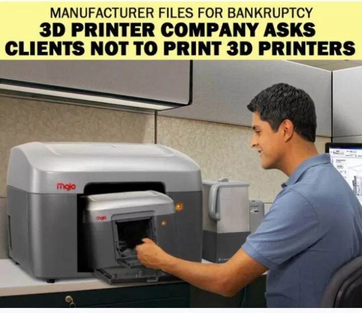 A man in a blue polo shirt is shown from the side, smiling as he interacts with a large grey 3D printer branded 'mojo' on…