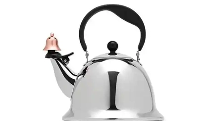A shiny silver kettle with a black handle and a small copper bell attached to its spout. The overlaid text reads 'i'm not a…