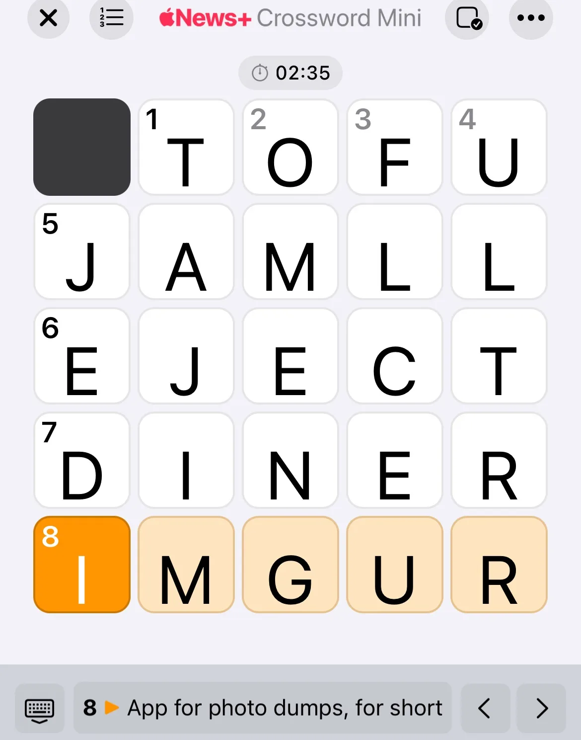 A screenshot of the Apple News+ Crossword Mini app shows a partially filled crossword grid with visible words like 'TOFU'…