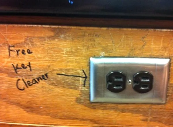 A close-up photo shows a wooden surface with handwritten text reading 'Free Key Cleaner' and an arrow pointing to a standard…