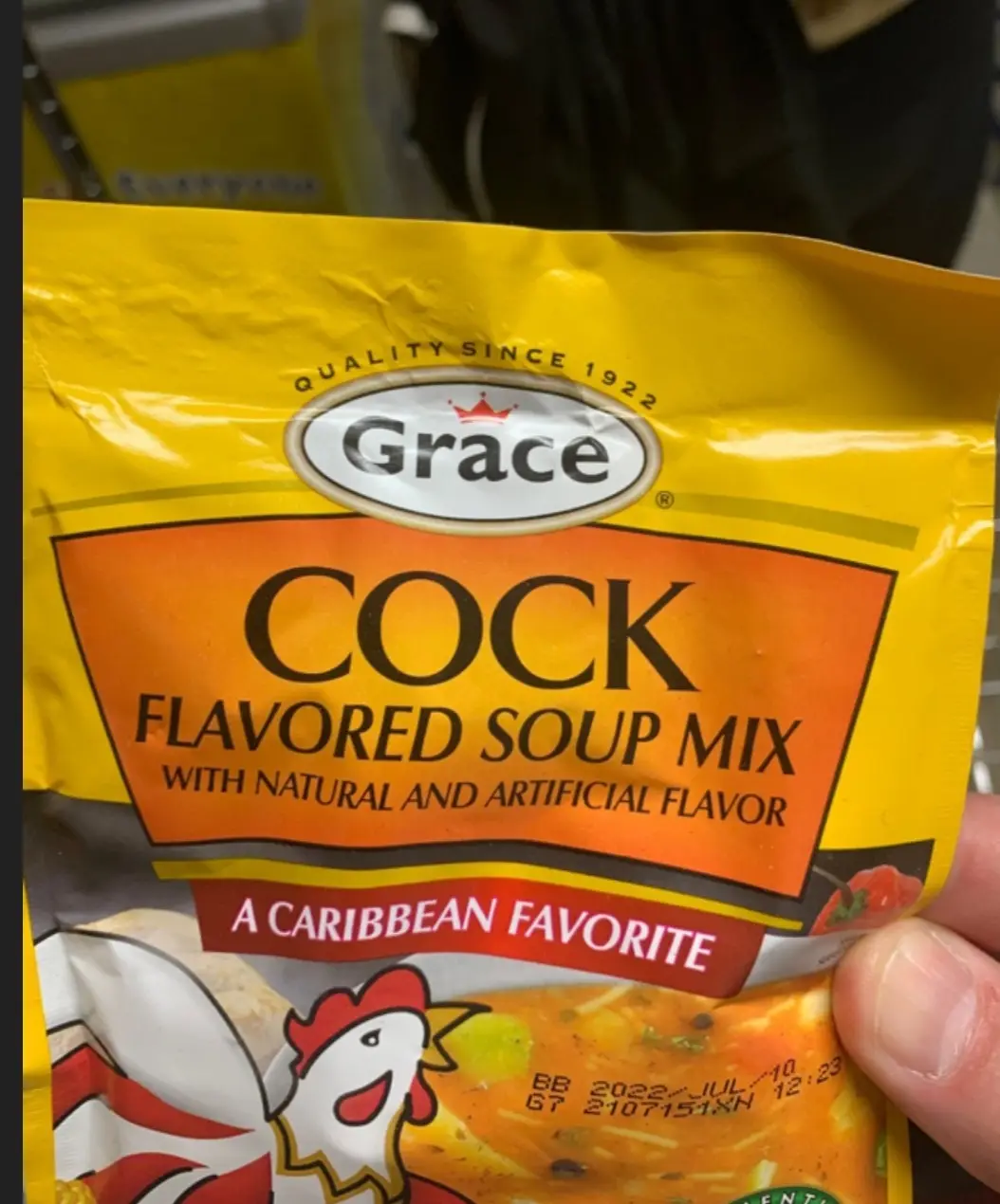 A close-up photo shows a hand holding a yellow bag of Grace brand soup mix. The packaging prominently displays the product…
