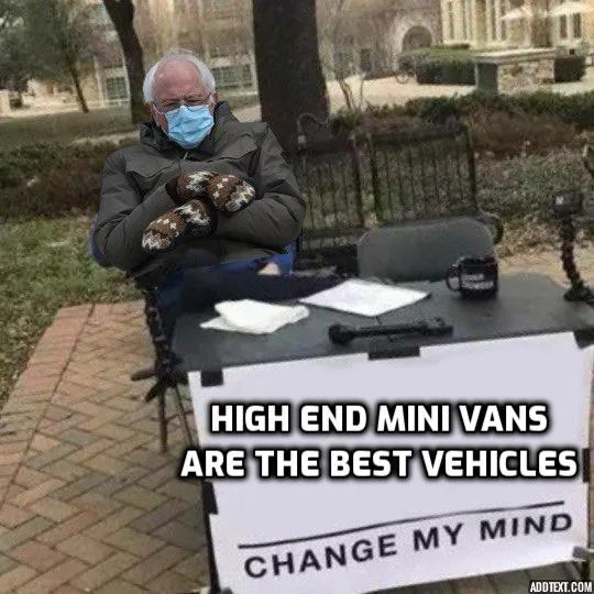 A man wearing a blue surgical mask and patterned mittens sits at a makeshift outdoor table with a sign that reads 'HIGH END…