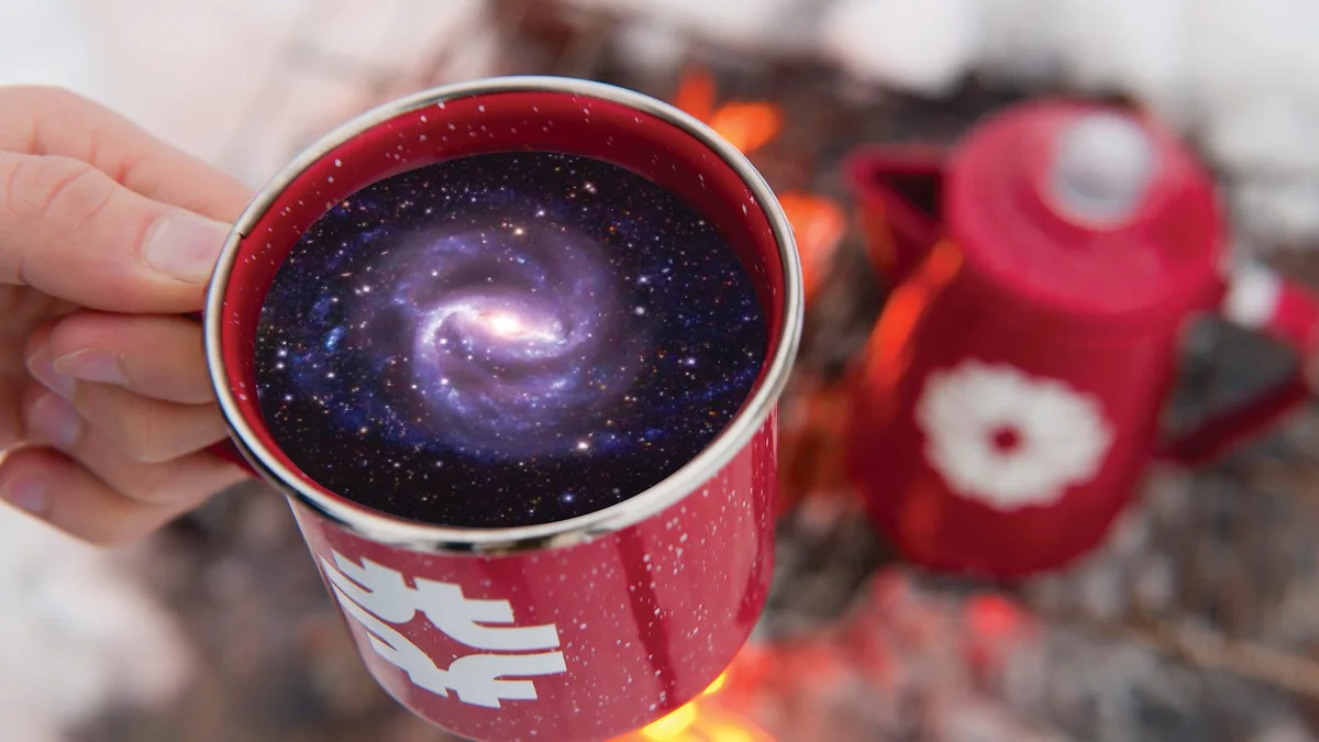 A hand holds a red enamel mug filled with a beverage that visually resembles a swirling galaxy, complete with stars and…