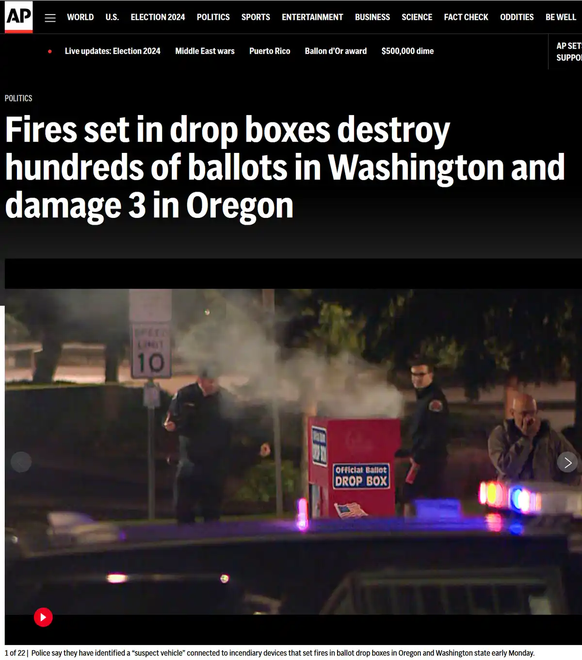 A nighttime news photo shows a red 'Official Ballot DROP BOX' smoking as police officers stand nearby. The headline reads…