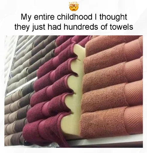 A close-up photo shows rows of rolled towels stacked neatly on shelves, with a visible gap revealing a large, pale yellow…