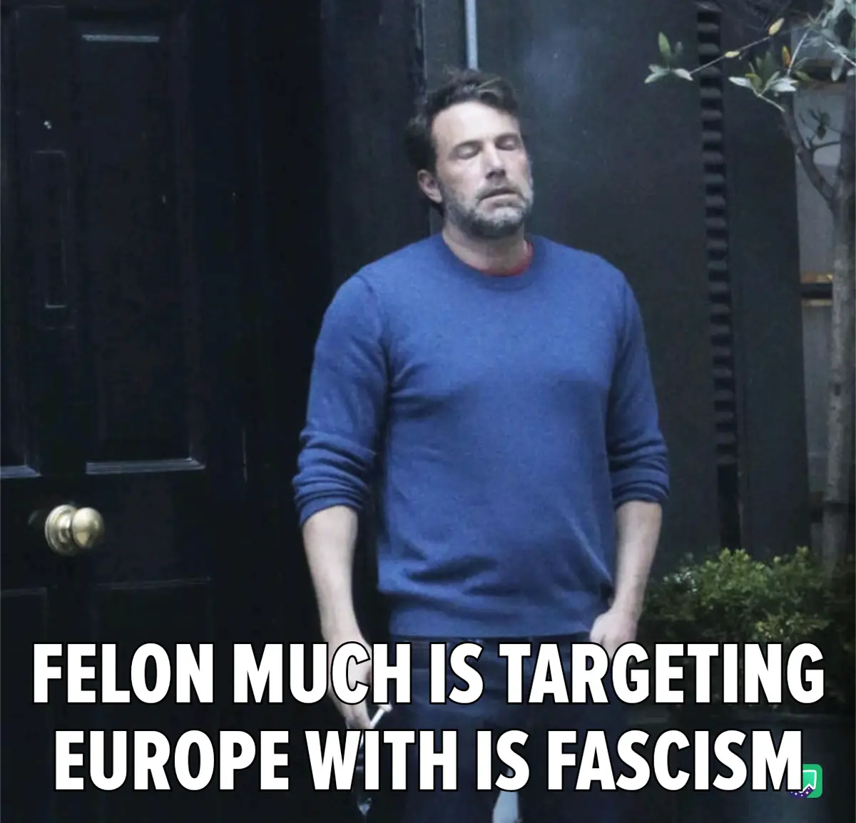 A man with a weary expression stands in front of a dark door, wearing a blue sweater over a red shirt. The overlaid text…