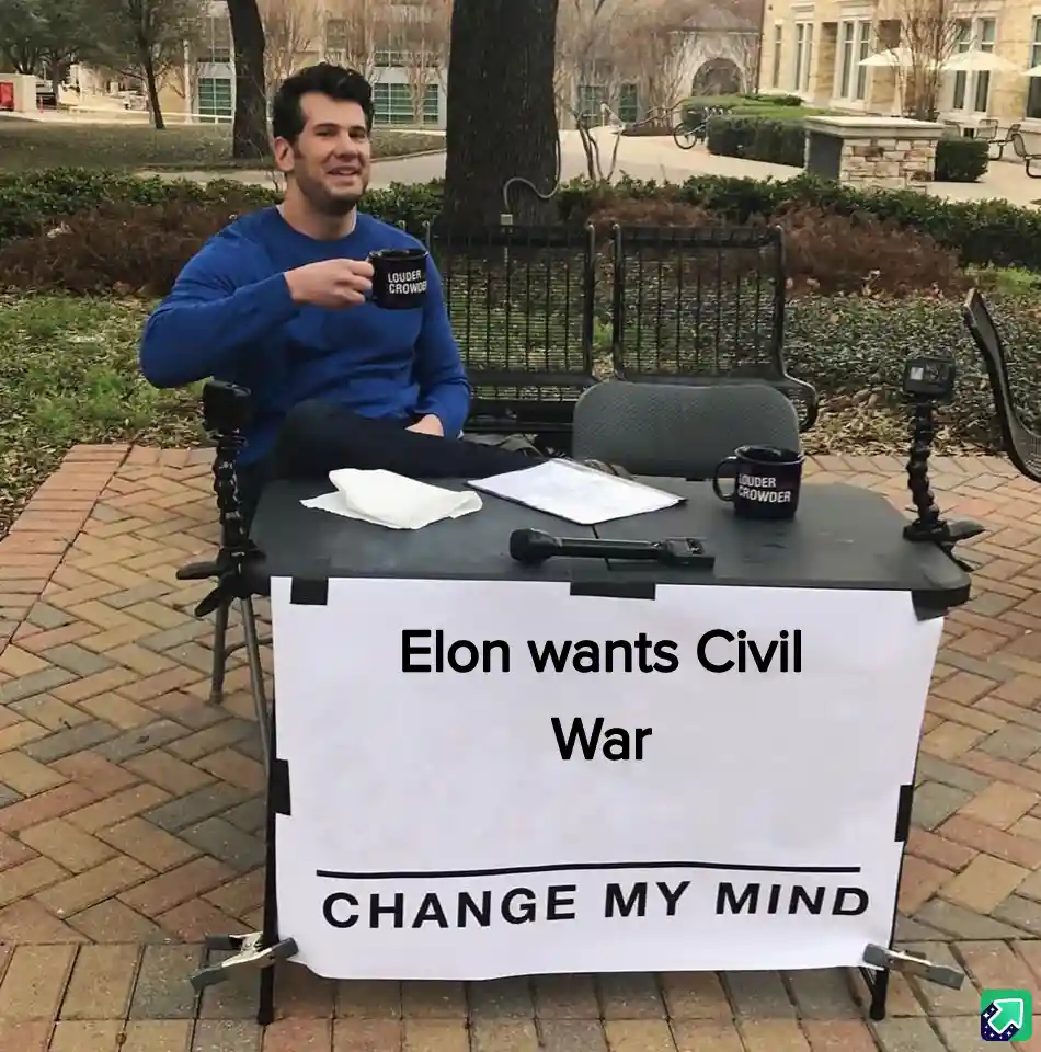 A man in a blue shirt sits at a small outdoor table with two mugs that say 'LOUDER CROWDER', a microphone, and papers. He…