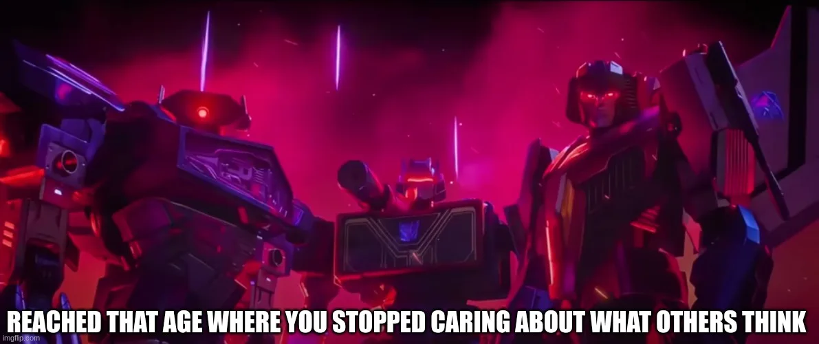 Three Transformers robots stand in a dark, red-lit scene with glowing eyes and weapons. The central robot is smaller…