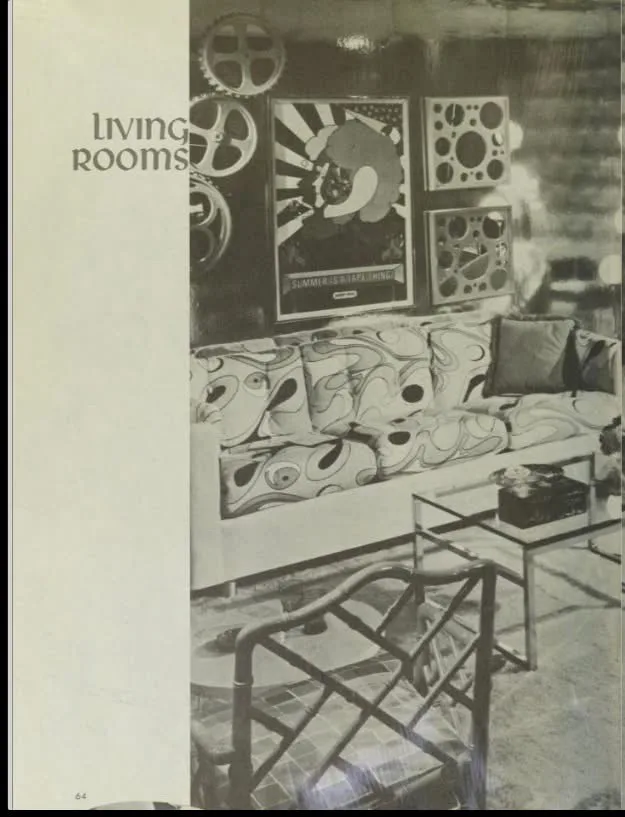 A black-and-white photo from a vintage interior design magazine page, showing a 1960s living room with a…
