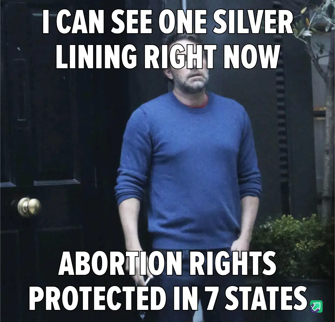 A man in a blue sweater stands outside a dark door with a weary, resigned expression. White bold text overlays the image: 'I…