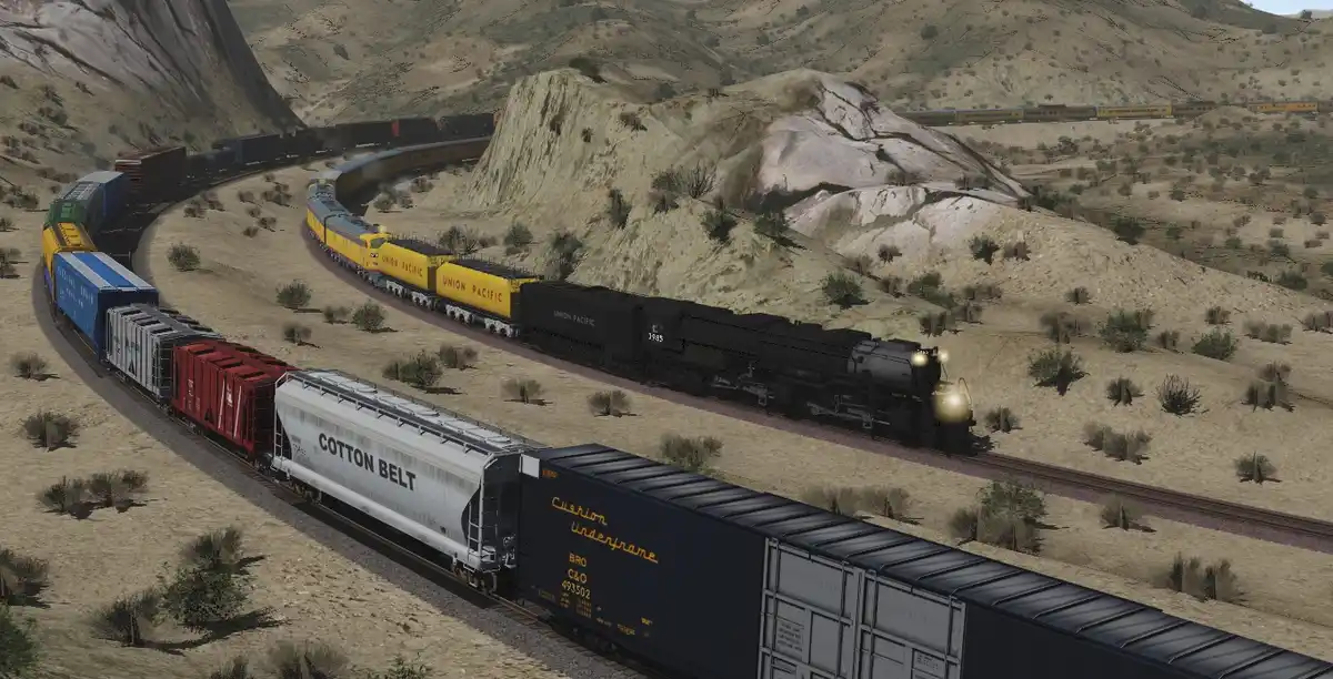 A screenshot from a train simulation game shows two trains on parallel tracks in a desert landscape. One train, in the…