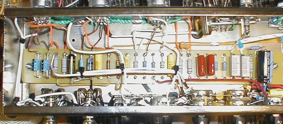 a close-up photo shows the interior of an electronic device with a densely packed, chaotic arrangement of wires, resistors…