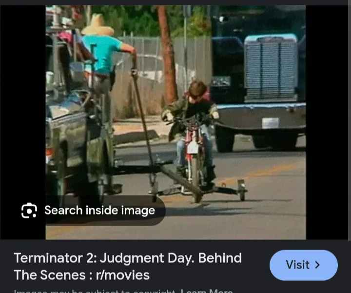 A behind-the-scenes photo from Terminator 2: Judgment Day shows a person in a cowboy hat and blue shirt standing on a…