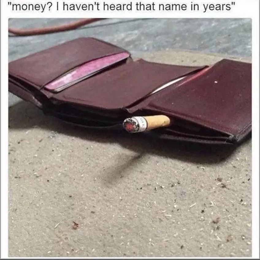 A dark brown leather wallet lies open on a concrete surface, revealing only a single lit cigarette protruding from one of…