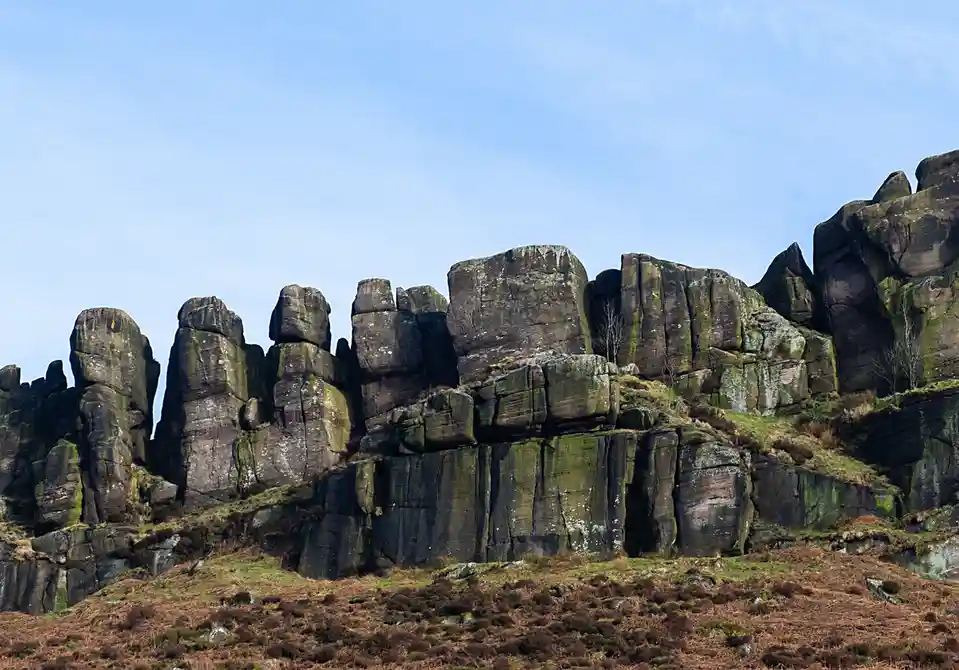 A scenic photo of a rugged, moss-covered rock formation under a clear blue sky, with the overlaid text 'i'm not a rock, i'm…