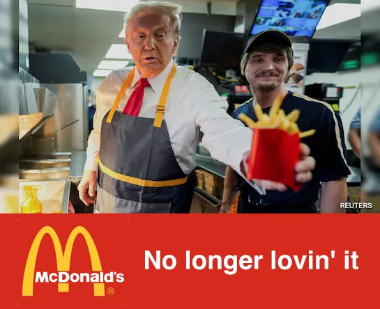 A man resembling Donald Trump, wearing a McDonald's apron and red tie, holds out a red fry container while looking…