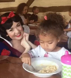 A six-panel sequence shows a young girl eating cereal while a costumed Snow White character interacts with her. Initially…