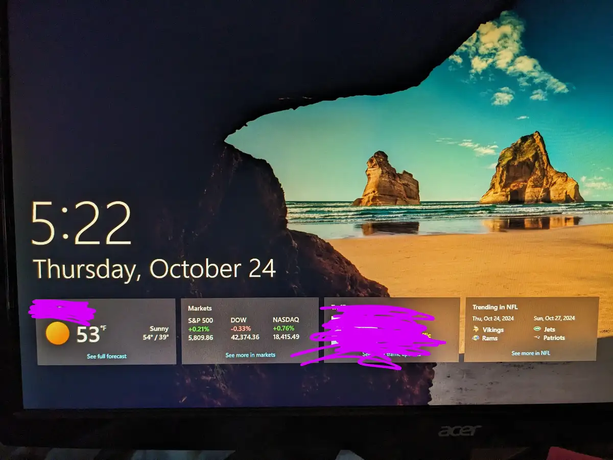 A computer screen displays a weather and news widget over a scenic beach wallpaper with rock formations. The time is 5:22…