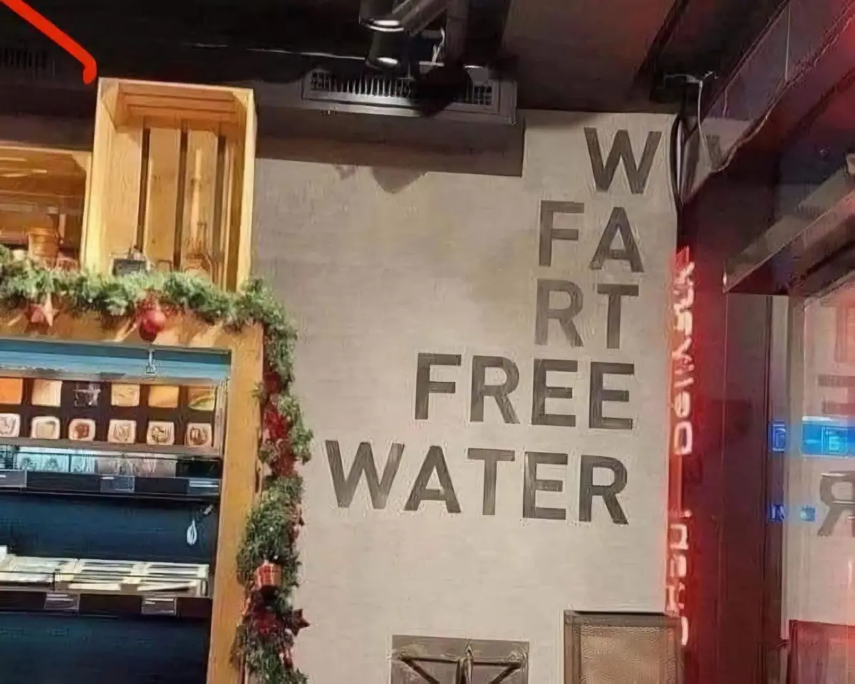 A wall inside a restaurant or bar has large, blocky letters painted on it that spell 'WART FREE WATER'. The text is arranged…