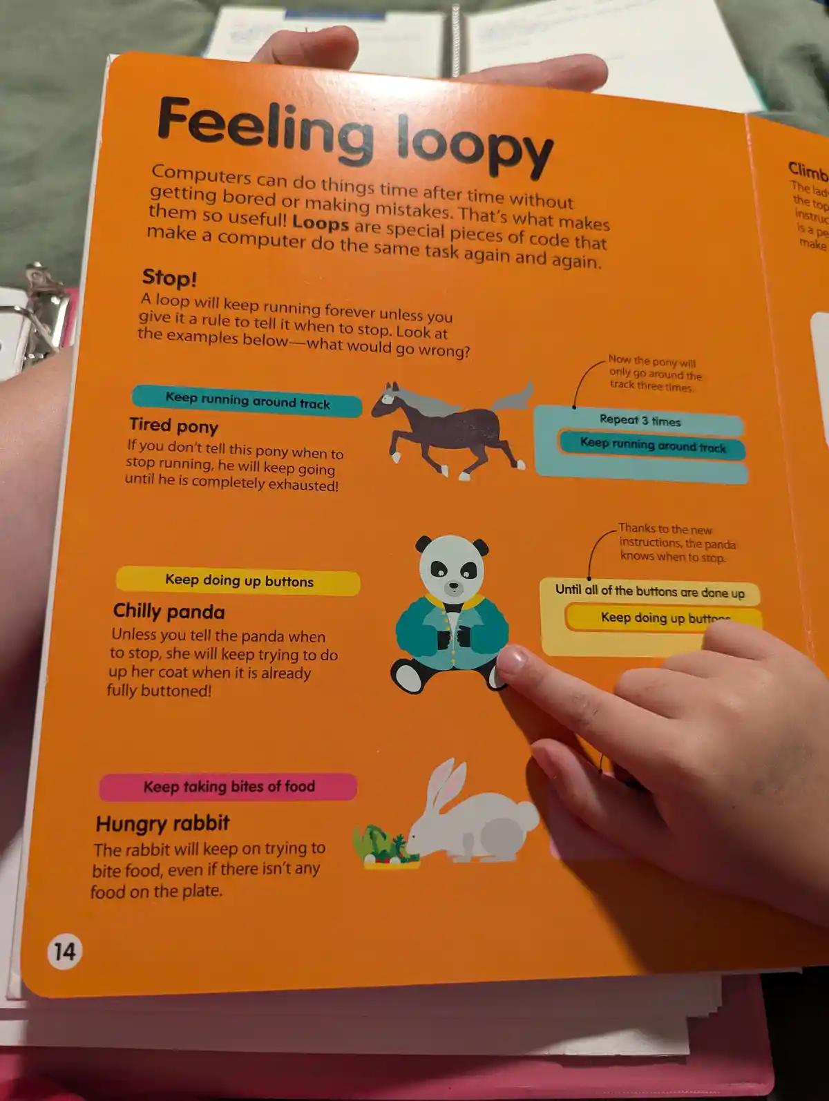 A person's finger points at a children's educational book page titled 'Feeling loopy,' which explains computer loops using…