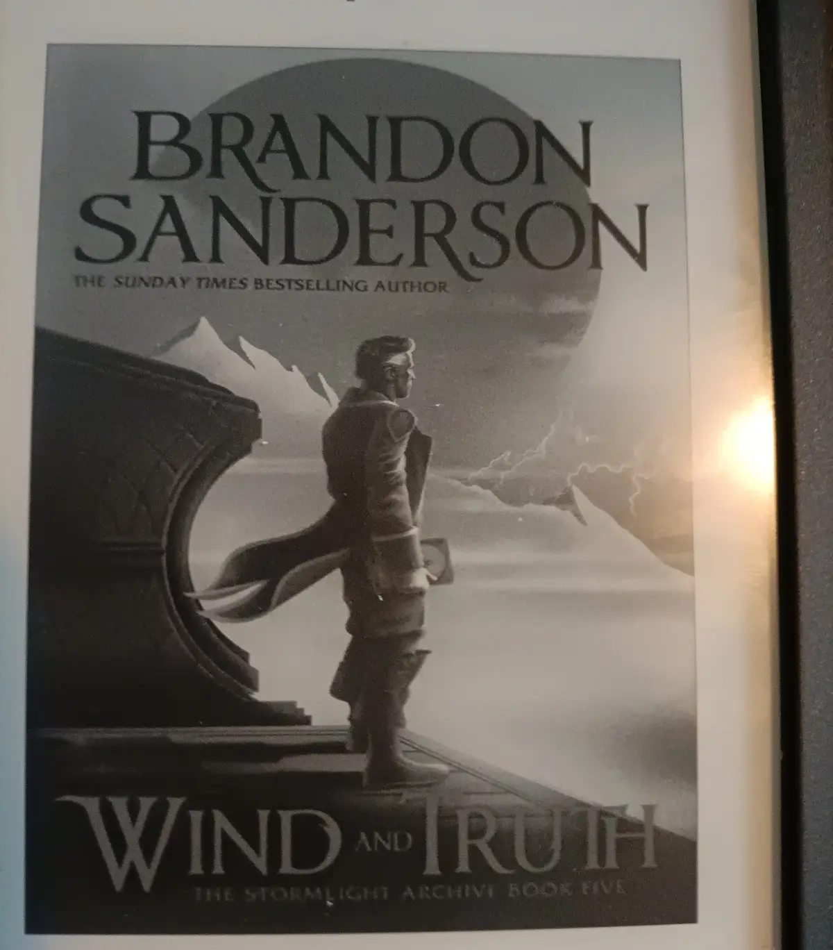 A black-and-white book cover for Brandon Sanderson's 'Wind and Truth,' the fifth book in 'The Stormlight Archive' series…