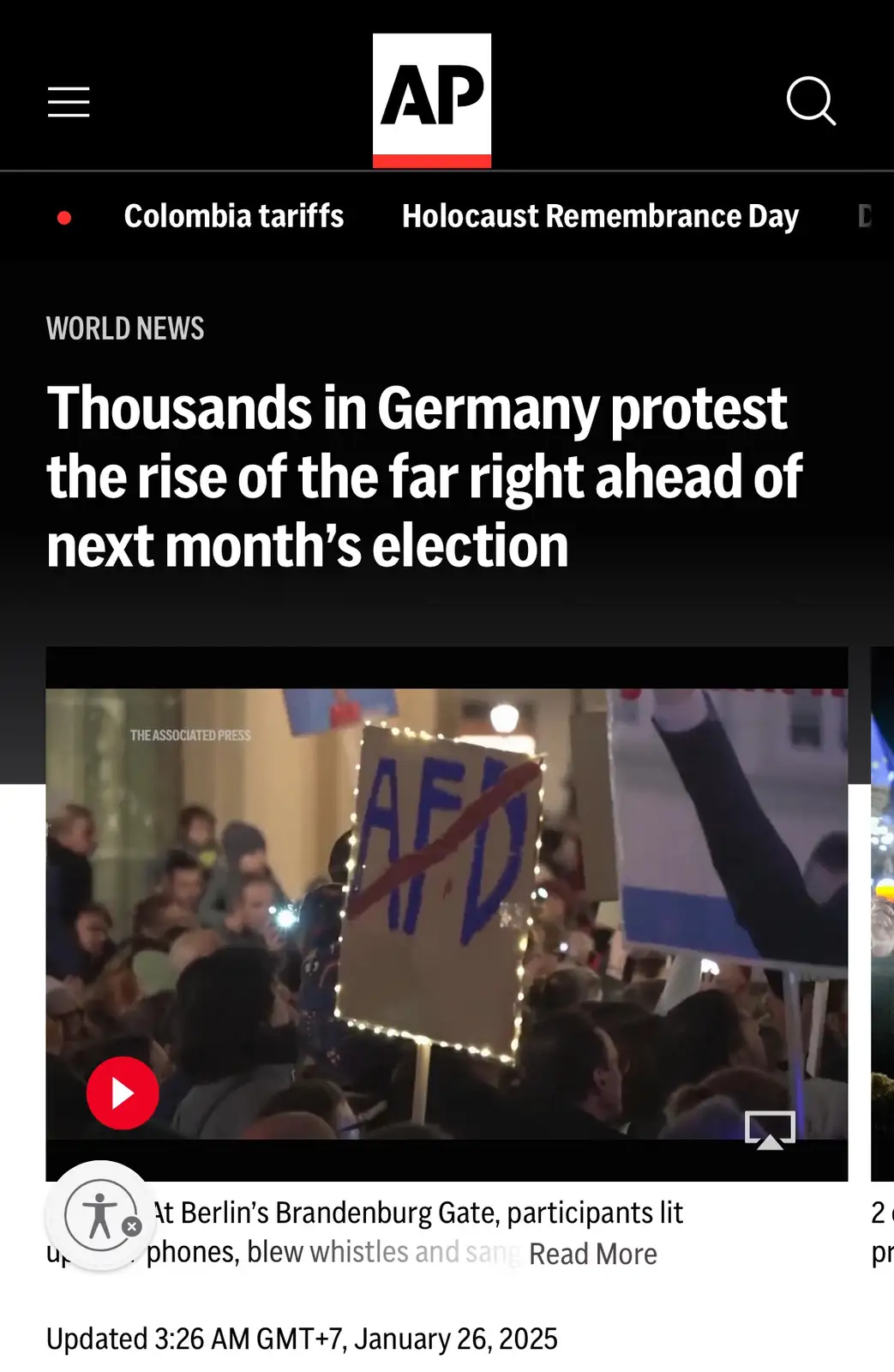 A screenshot of an Associated Press news article shows a protest in Germany with a crowd holding signs, one prominently…