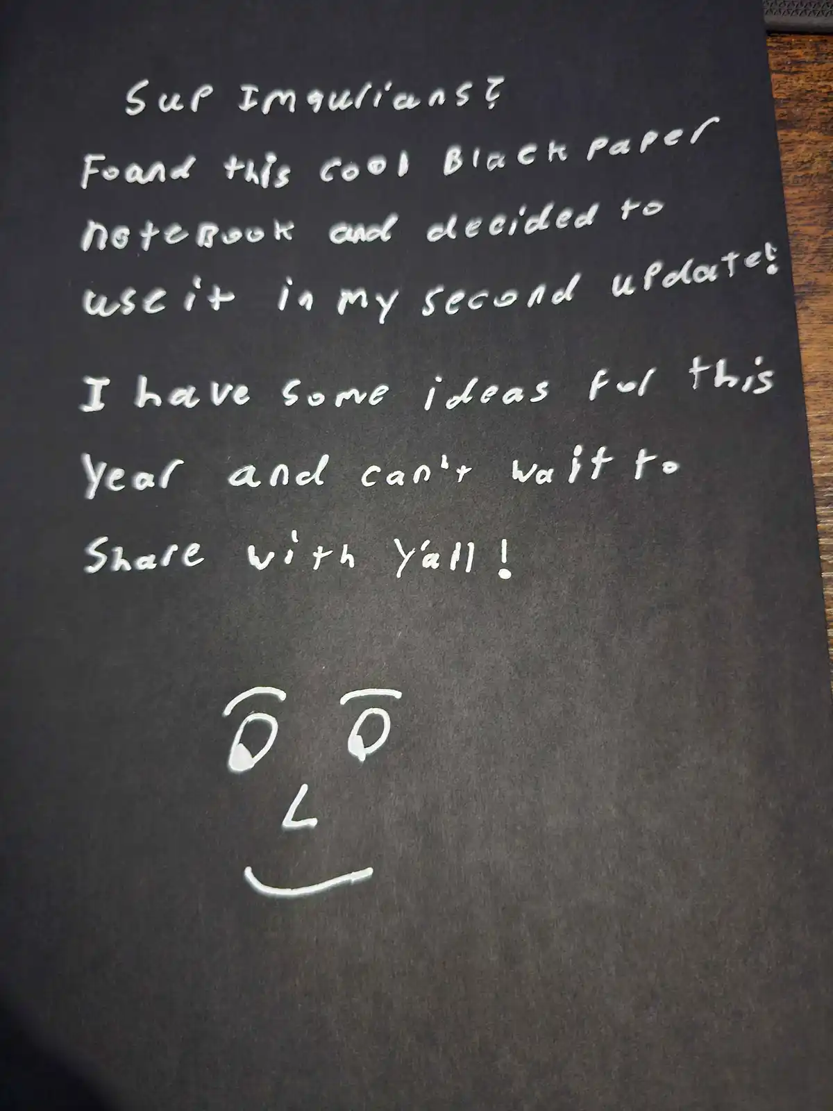 A close-up of a black notebook page with white handwritten text that reads 'Sup Imqulians? Found this cool Black paper…