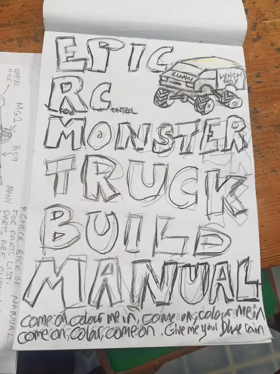 A hand-drawn, childlike sketch on paper shows a crude drawing of an RC monster truck with 'LUNCH BOX' written on its side…