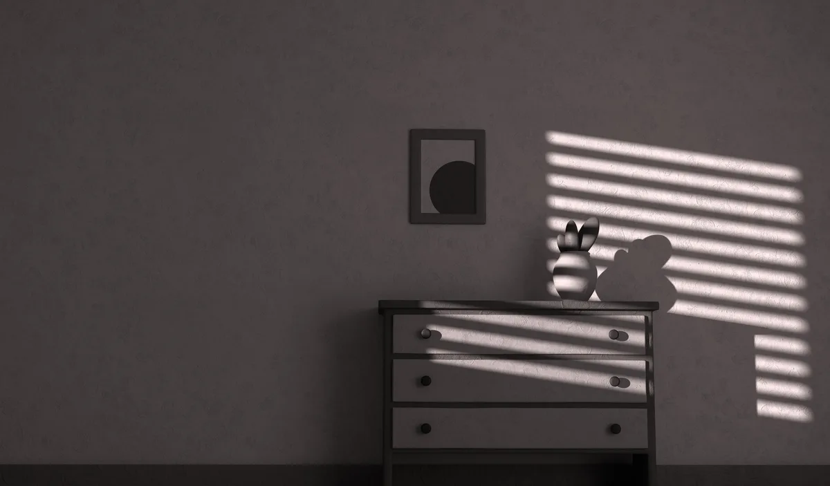 A minimalist, monochrome room scene features a wooden dresser with three drawers, a small potted plant on top, and a framed…