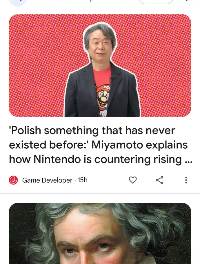 The image shows a man with gray hair wearing a black blazer over a red t-shirt with a Mario graphic, set against a bright…