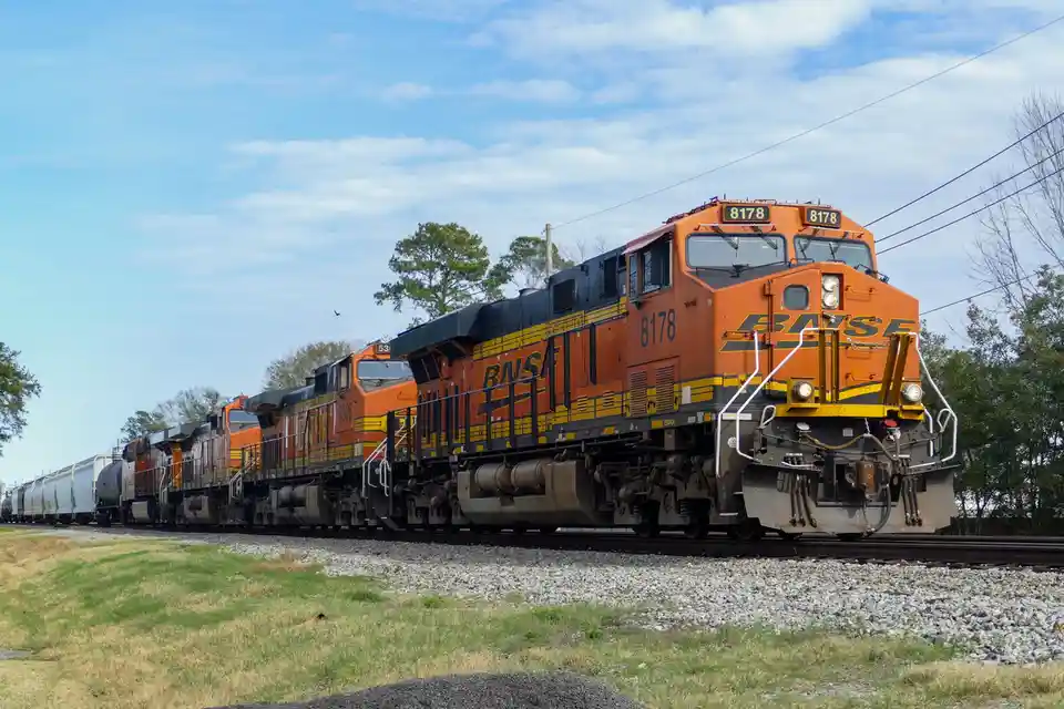 A BNSF freight train with locomotive number 8178 prominently displayed on its front and sides, pulling multiple freight cars…