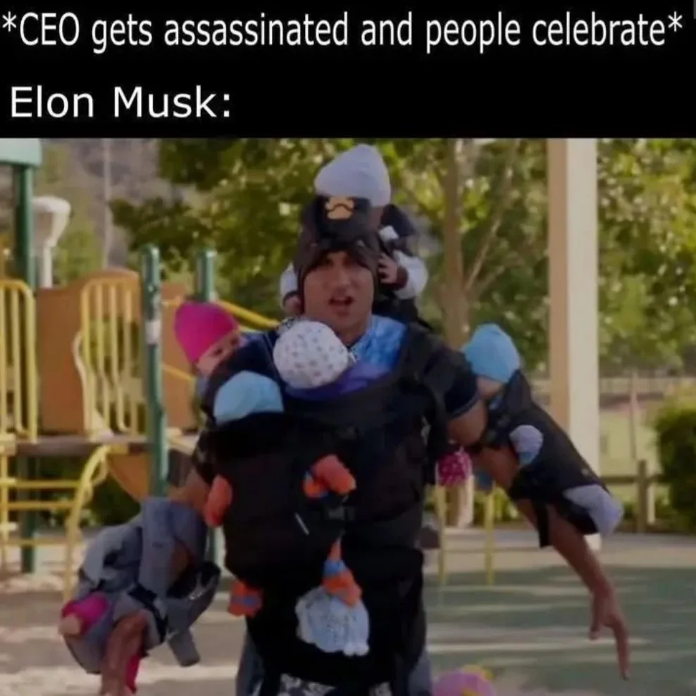 A man in a playground setting is overloaded with multiple babies strapped to his body and arms, looking overwhelmed and…