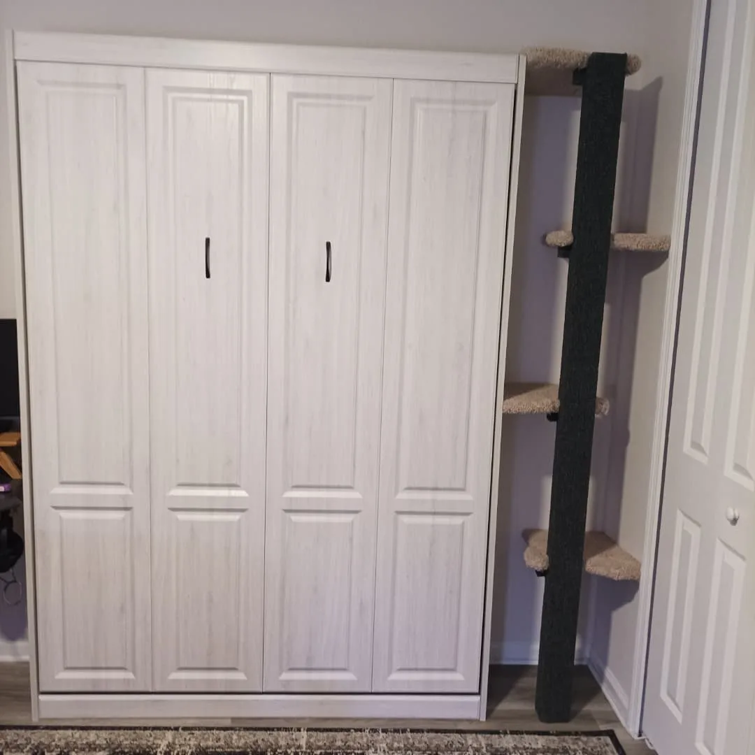 A white, four-door wardrobe stands next to a tall, black cat tree with multiple beige platforms. The overlaid text reads 'i…