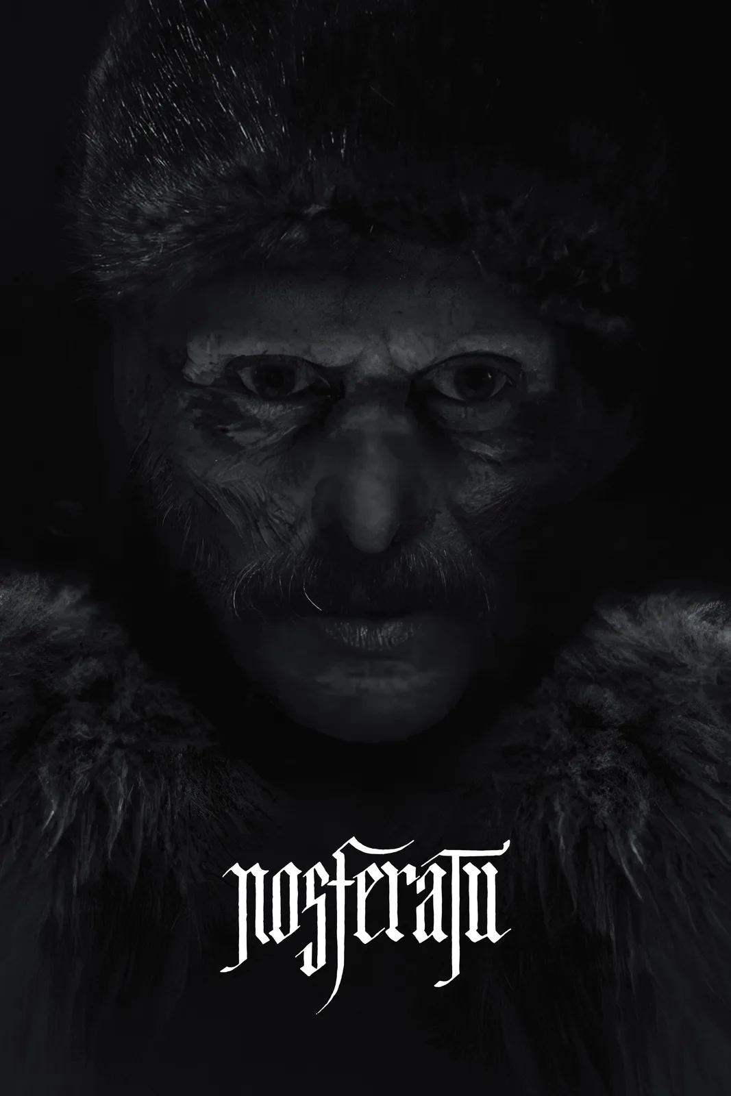 A black-and-white close-up of a man with a fur hat and coat, his face showing deep wrinkles and a mustache, staring…